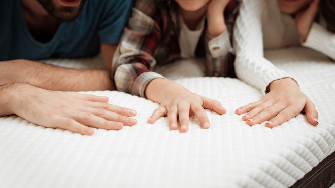 family testing out a mattress topper with their hands
